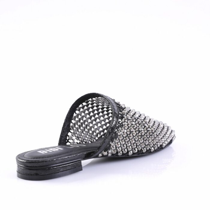 Black slide sandal covered in metallic studs with an open back and flat sole.