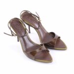 Brown patent leather high-heeled sandals with thin ankle straps and open toes, on a white background