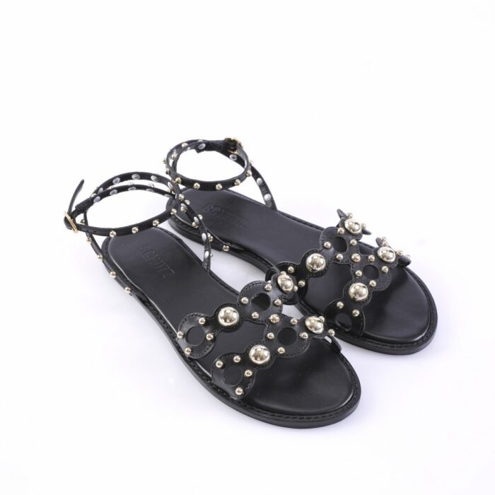 Black studded flat sandals with ankle straps and decorative metal beads, open toe design.