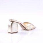 Gold metallic open-toe sandal with a short block heel on a white studio background