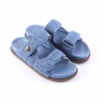 Blue denim slide sandals with two Velcro straps and a brown sole, open-toe design.
