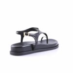 Black leather thong sandal with an ankle strap and gold buckle on a white studio background.