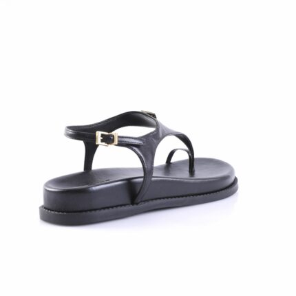 Black leather thong sandal with an ankle strap and gold buckle on a white studio background.