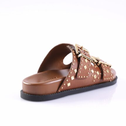 Brown leather slide sandal with gold-tone studs and buckled straps on a black sole, shown from a side angle.
