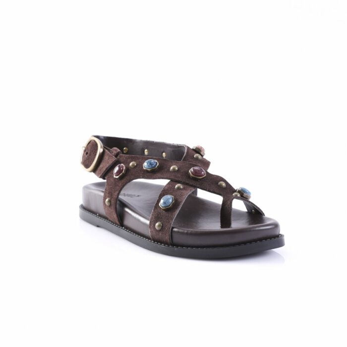 Brown suede sandal with decorative metal studs and colorful gemstone accents, open toe and ankle strap.