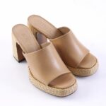 Beige open-toe platform sandals with woven jute-style heels and wide leather straps, brand name Schütz visible inside soles