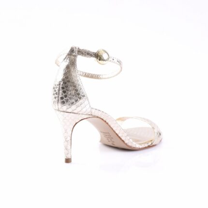 Silver snakeskin-embossed high-heeled sandal with a thin ankle strap and a gold ball accent on the strap.