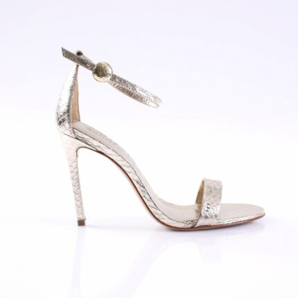 Silver snakeskin high-heeled sandal with an ankle strap and toe band, featuring a gold ball embellishment on the strap.