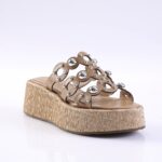Beige platform sandal with a woven espadrille-style sole and decorative metal studs on the straps.