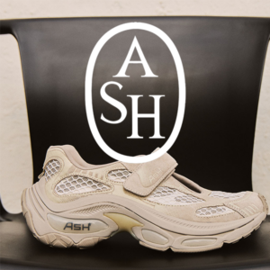 Beige ASH athletic sneaker on a black chair with a large white oval ASH logo overlayed above the shoe.