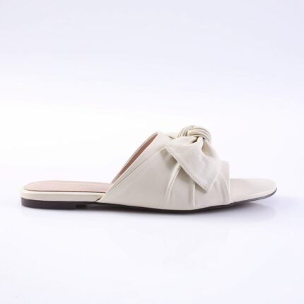 Cream-colored slide sandal with a twisted knot strap across the top and a flat sole.