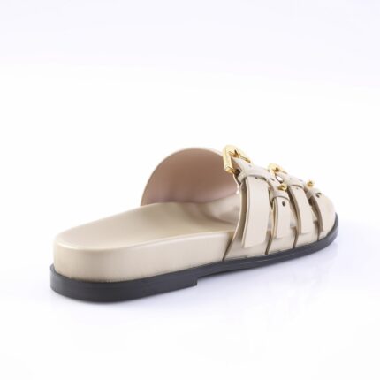 Beige flat sandal with three strapped bands and gold buckles on a black sole