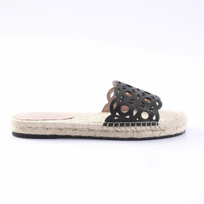 Black cut-out slide sandal with a woven jute sole on a white background, product photo.