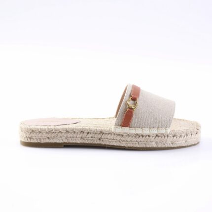 Beige espadrille slide with rope-wrapped sole and fabric strap featuring pink leather accent and gold hardware from a side view (product photo)