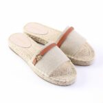 Beige espadrille slide sandals with woven jute sole and tan leather strap.