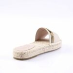 Beige espadrille slide sandal with a woven rope sole and fabric strap, shown from the side with a small gold buckle detail.