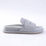 Light gray suede slide sandal with a wide Velcro strap and a light brown sole, shown from the side.