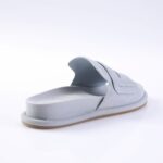 Light gray slide sandal with a padded footbed and wide stitched strap, viewed from the back-left side.