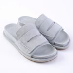 Light gray suede slide sandals with two wide straps and open toes on a white background, casual footwear