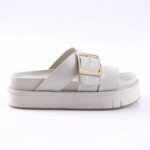 White platform slide sandal with a wide strap and gold square buckle on a chunky sole.
