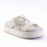 White platform sandal with a chunky sole and two straps, featuring a gold square buckle.