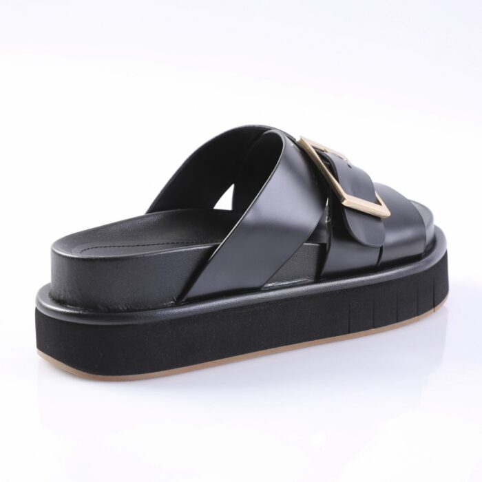 Black platform slide sandal with two straps and a gold buckle on a white background, showing the chunky sole and glossy straps.