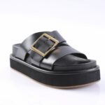 Black platform sandal with wide straps and a gold square buckle on a white background