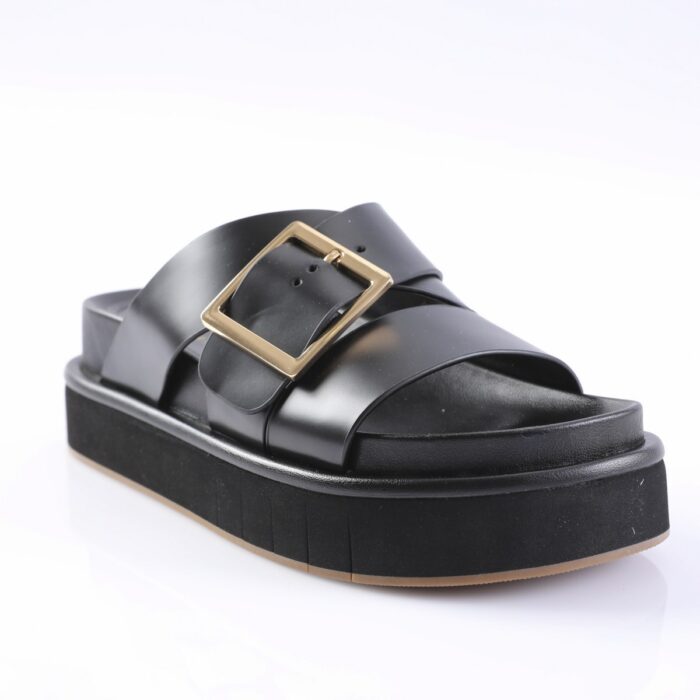 Black platform sandal with wide straps and a gold square buckle on a white background