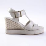 White wedge sandal with braided jute heel, white straps, and a gold buckle set on a platform sole