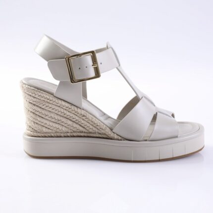 White wedge sandal with braided jute heel, white straps, and a gold buckle set on a platform sole