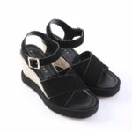 Black wedge sandals with ankle straps and beige braided rope heel; platform sole on a white background.
