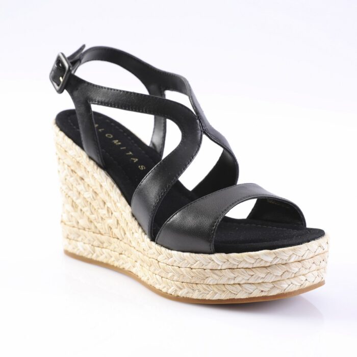 Black leather wedge sandal with strappy design and ankle buckle, featuring a natural braided-jon sole on a white background