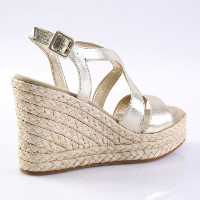 Gold metallic wedge sandal with braided jute platform and ankle strap on a light background