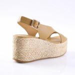 Beige platform wedge sandal with braided rope sole, tan leather straps, and ankle buckle