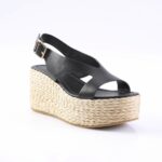 Black leather wedge sandal with a braided jute platform and ankle strap with a gold buckle.