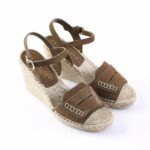 Brown suede wedge sandals with ankle straps and white stitched detailing on the toe straps, jute-wrapped sole.