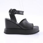 Black platform wedge sandal with stitched leather straps and ankle buckle.