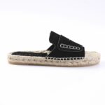 Black suede espadrille slide sandal with a woven rope sole and stitched strap detail on a white background.