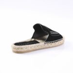 Black espadrille sandal with a woven rope sole and black fabric top, side stitching detail visible on the strap