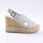White wedge espadrille sandal with braided jute sole and white leather straps, buckle ankle strap, side view
