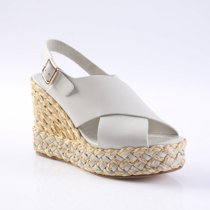 White wedge espadrille sandal with a braided jute sole and white leather straps, featuring a gold buckle on the ankle strap