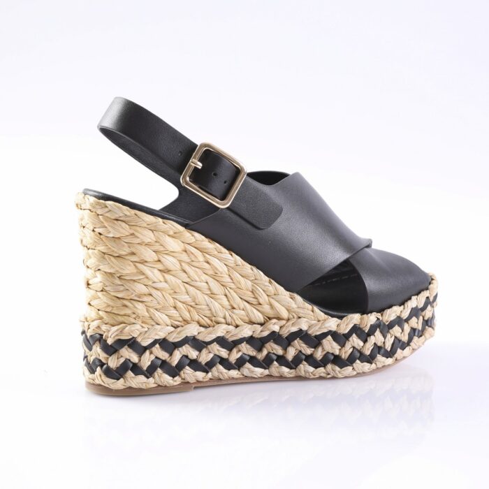 Black leather wedge sandal with an ankle strap and gold buckle, set on a woven braided-strap espadrille platform
