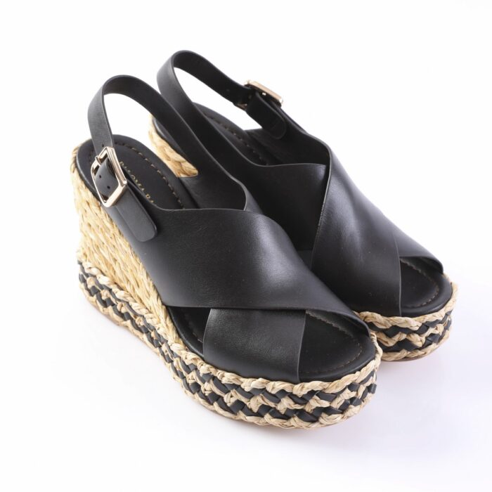 Black leather wedge espadrille sandals with ankle straps and buckles, featuring a braided jute platform and open toes.