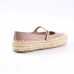 Pink leather espadrille with woven straw platform and a small Mary Jane strap.