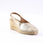 Gold metallic wedge espadrille with ankle strap on a braided jute sole, white background.