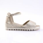 Gold metallic wedge sandal with an ankle strap and braided espadrille heel on a white background.