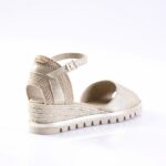 Beige metallic platform sandal with a braided espadrille-style wedge and ankle strap with buckle.