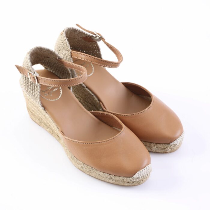 Tan leather espadrille wedge sandals with ankle strap and braided jute sole, on a white background.