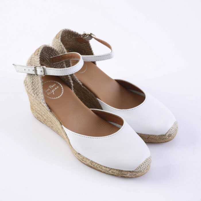 White espadrille wedge sandals with ankle straps and woven jute sole on a white background, front view.