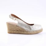 Silver metallic wedge sandal with an ankle strap and buckle on a braided jute espadrille heel